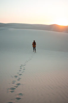A solitary figure walking away from eight golden cups under a twilight sky, symbolizing introspection and moving on.