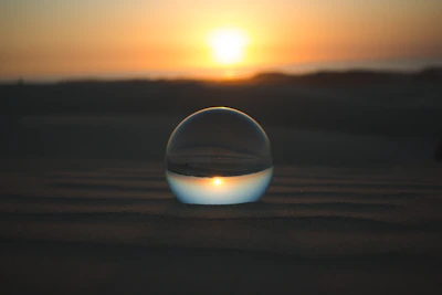 A serene crystal ball glowing softly on a wooden table surrounded by flickering candles.