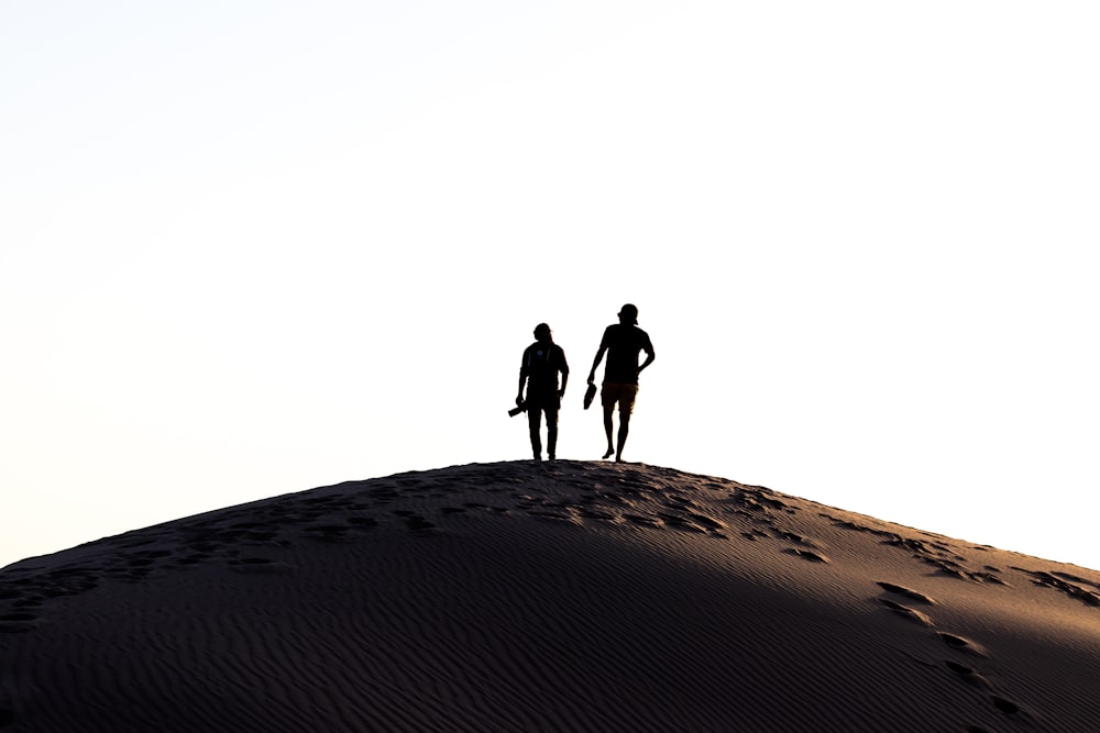 two person walking on desert