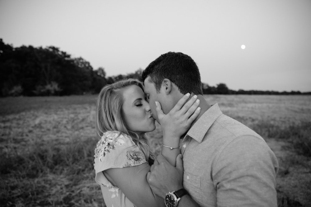 Photographie en niveaux de gris d’un couple s’embrassant