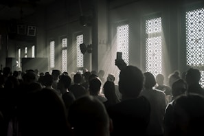 A candid shot of guests enjoying an elegant event, framed with natural light and subtle shadows.
