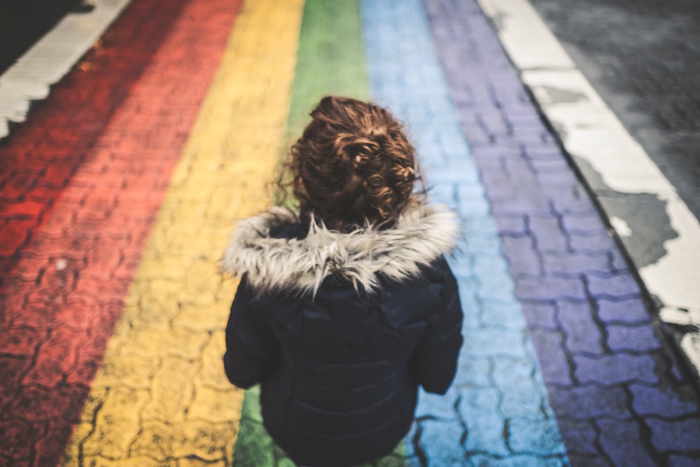 Mujer de pie sobre pavimento de hormigón multicolor durante el día