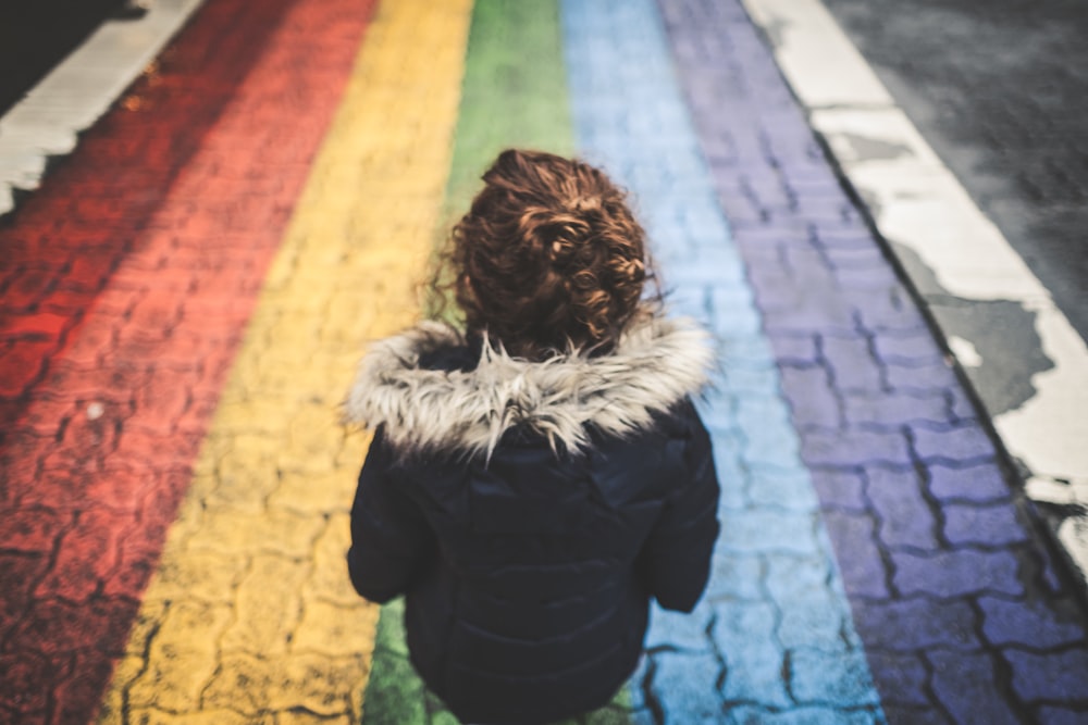 Femme debout sur un trottoir en béton multicolore pendant la journée