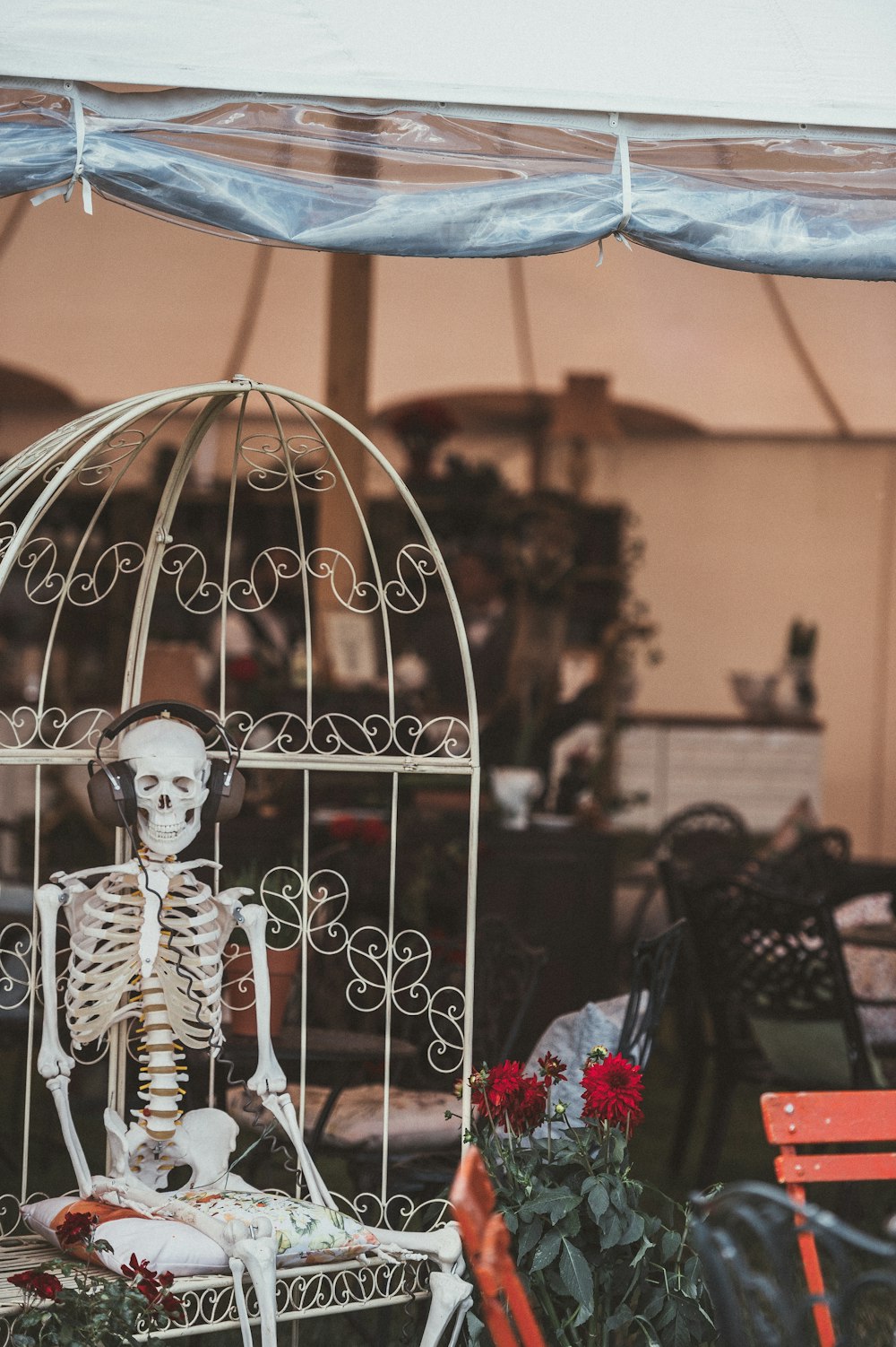 human skeleton wearing headphones while sitting in white steel egg chair