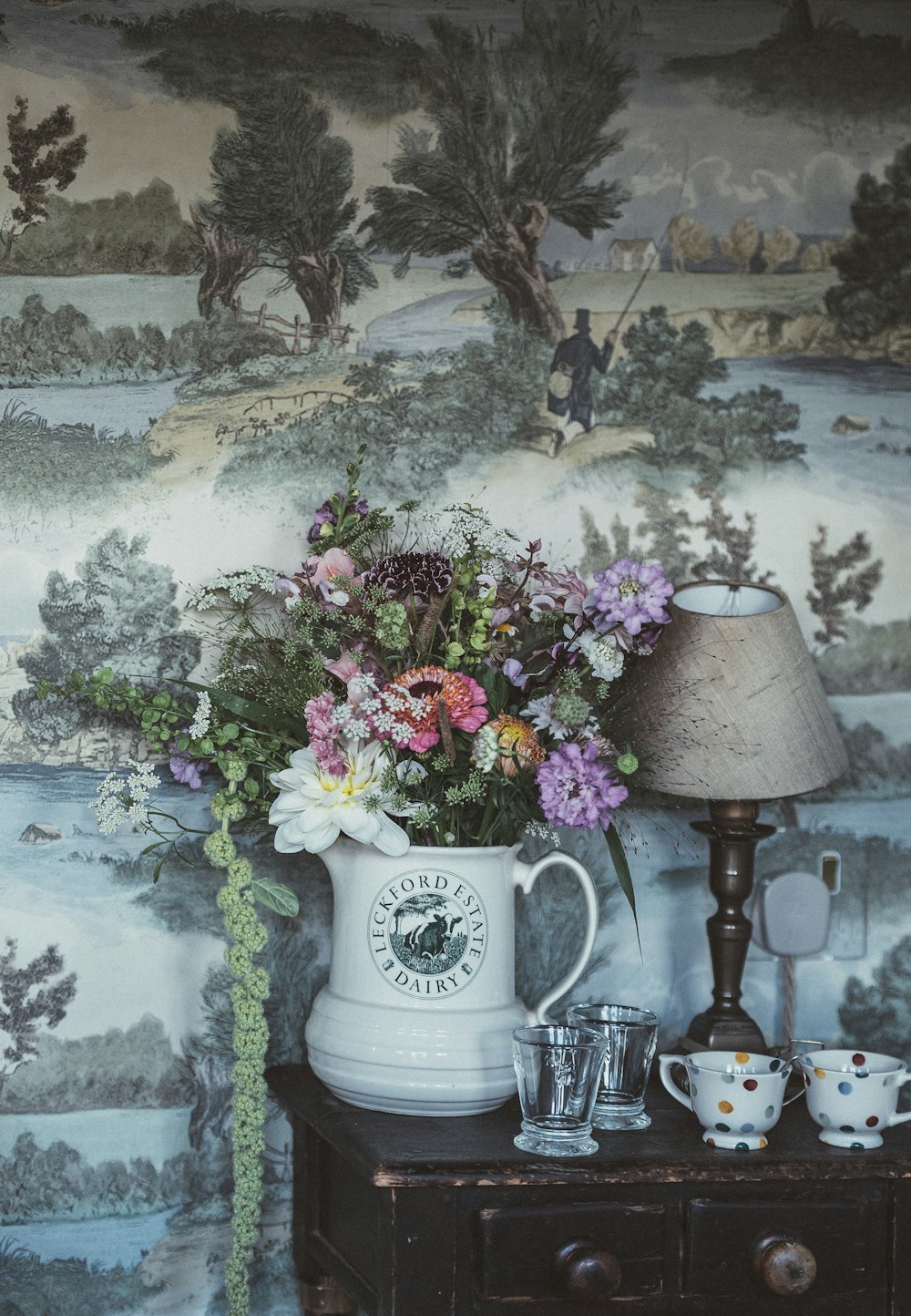 white ceramic pitcher with flowers on brown wooden table