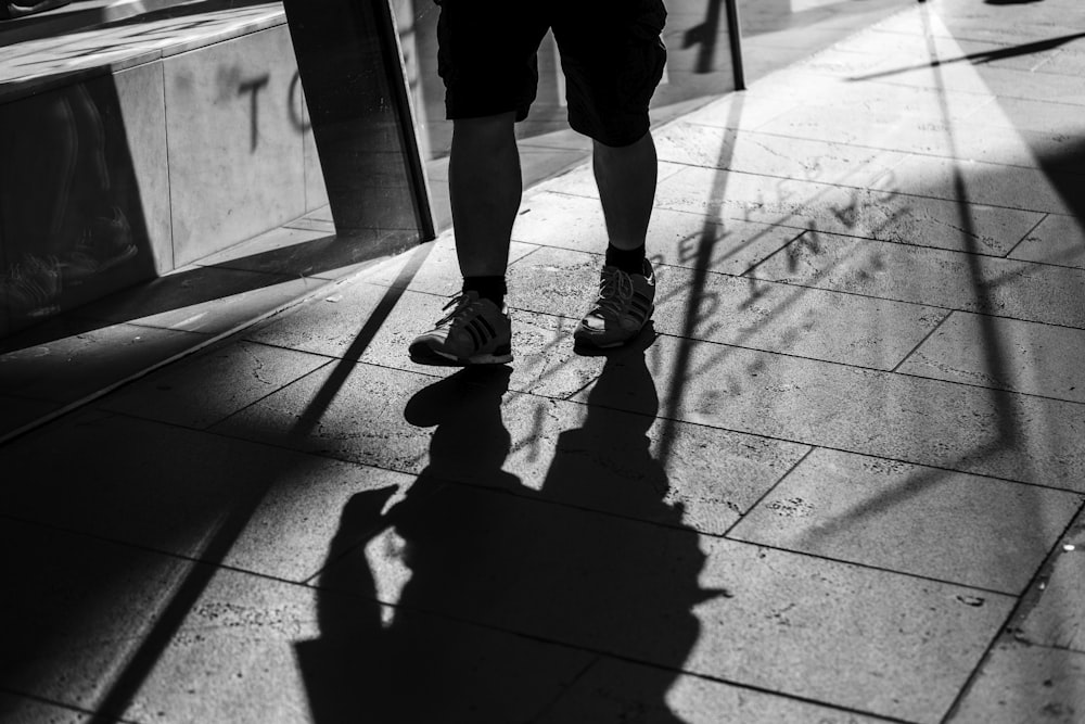 pessoa em pé no pavimento de concreto contra a luz