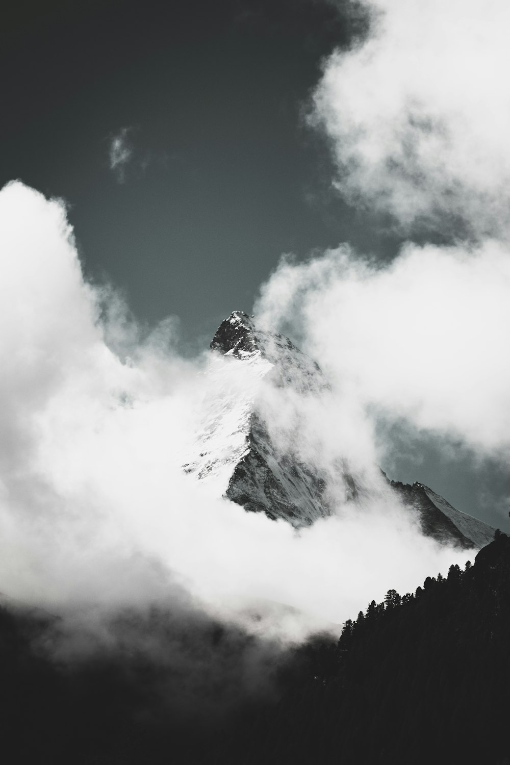 구름으로 덮인 산의 회색조 사진
