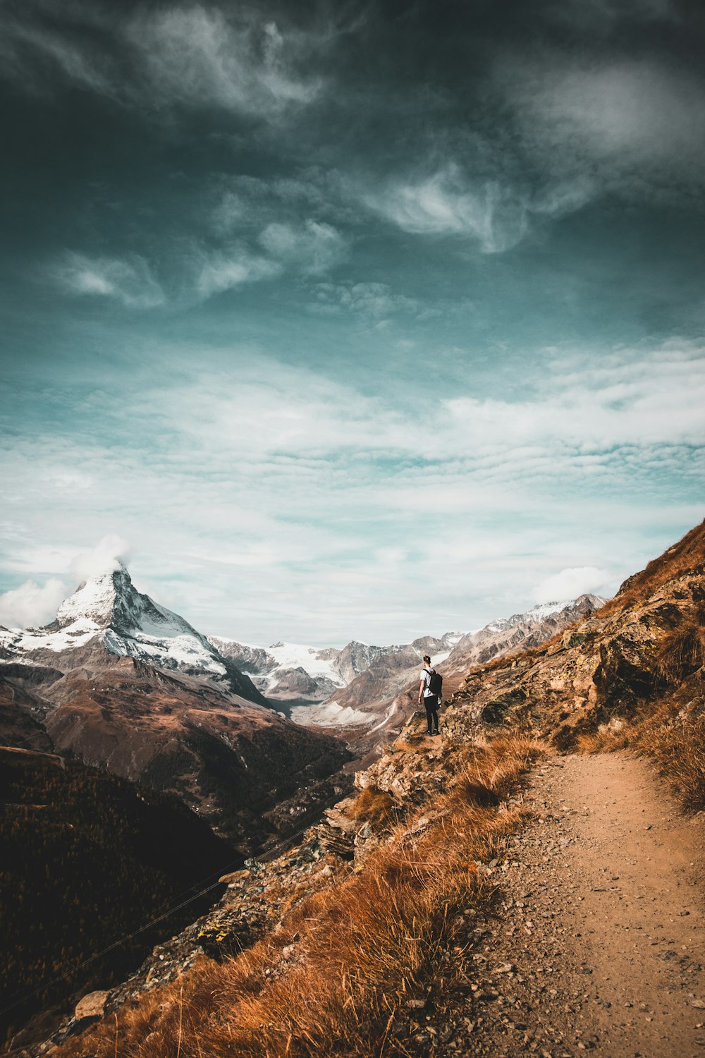 man standing while looking at mountain range