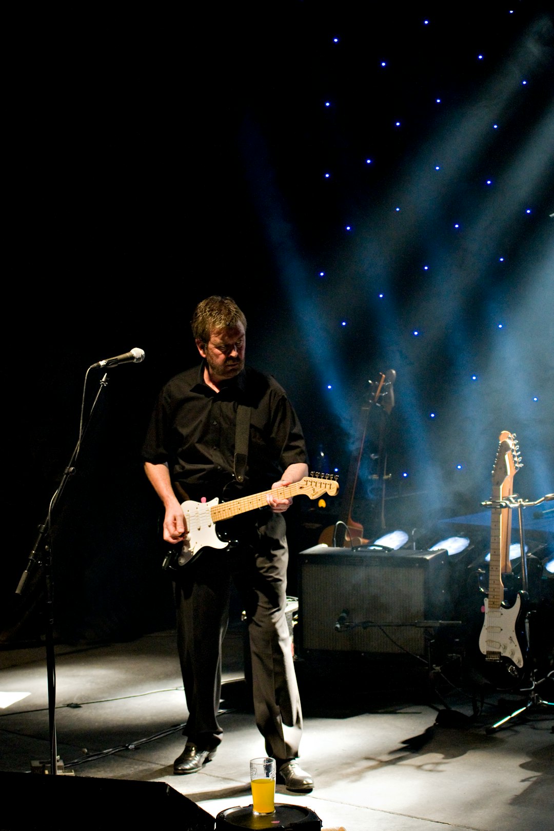 man playing guitar in front of microphone