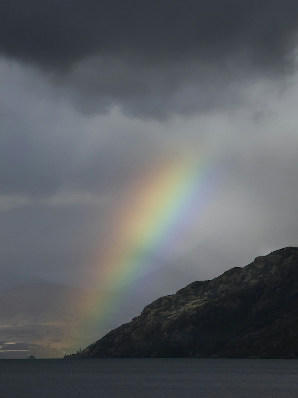 Foto del arco iris bajo las nubes de nimbo