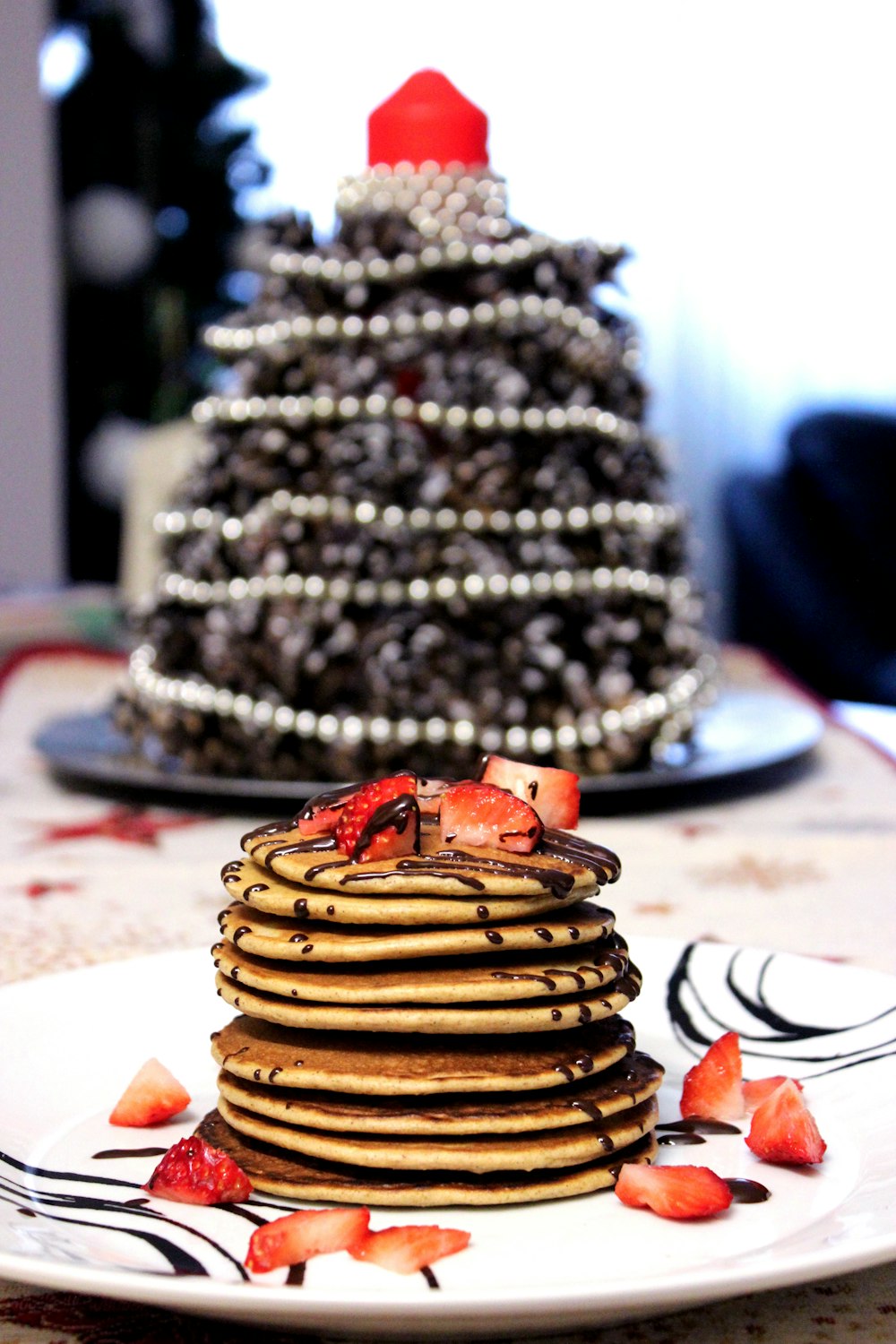 pancakes with chocolate syrup and strawberry toppings