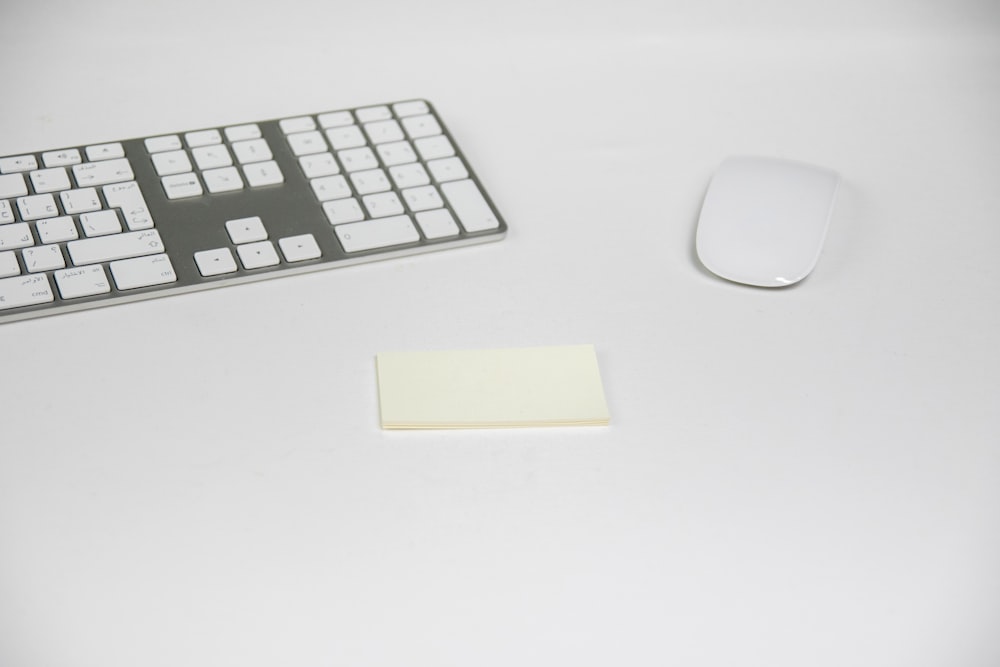 two white Apple Magic Mouse and Keyboard