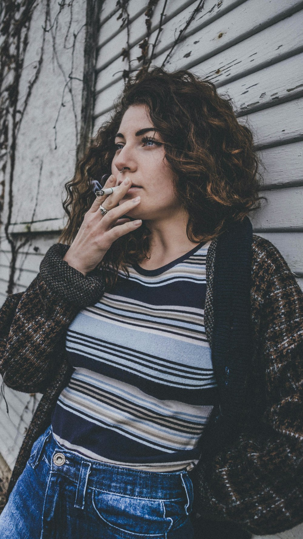 mulher na jaqueta marrom e preta usando cigarro