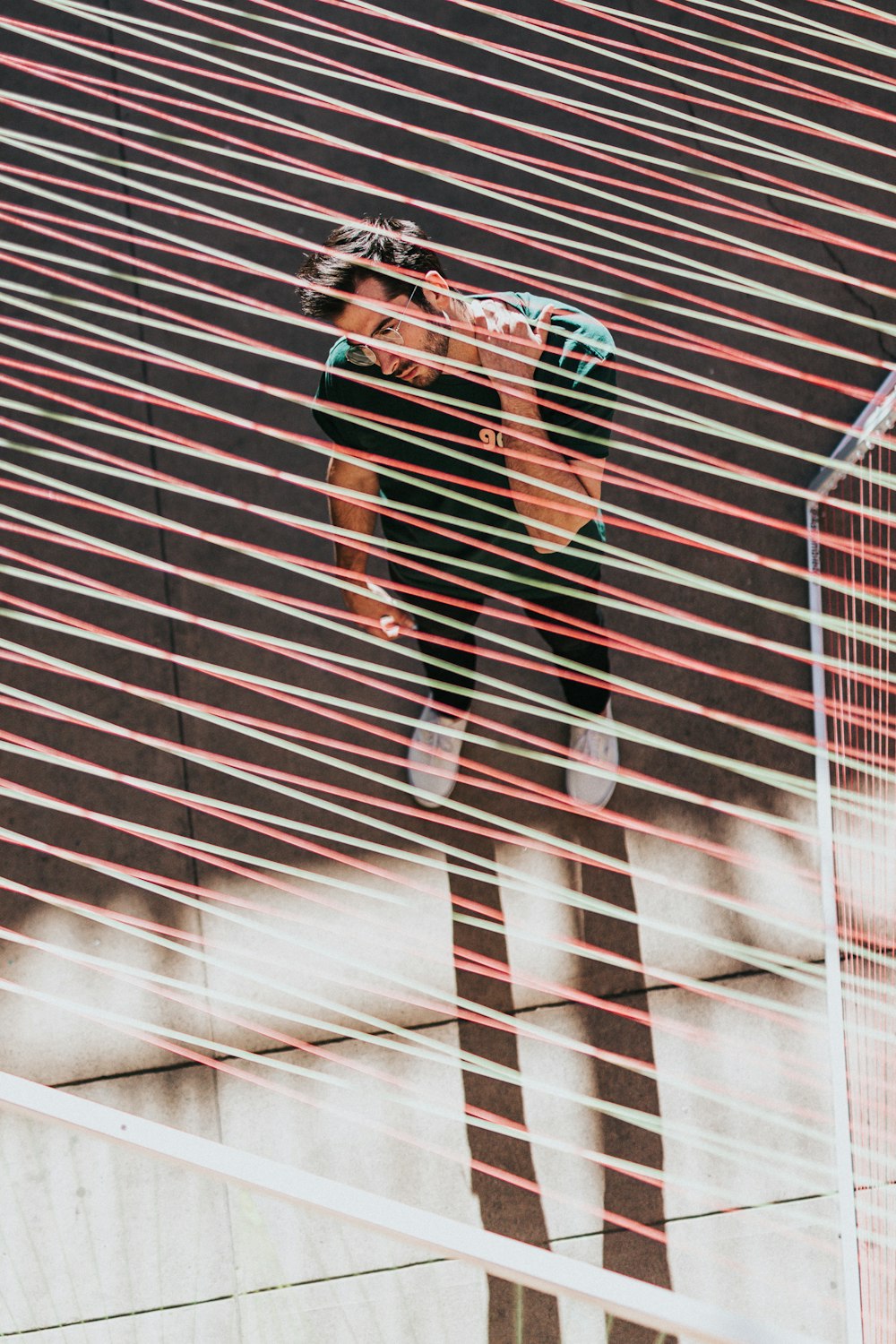 man in green shirt standing under red and green wires