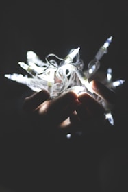 Hands packaging a delicate lighting fixture carefully for shipping.