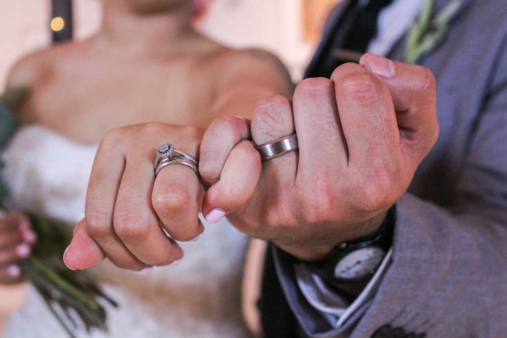 homem e mulher mostrando anéis prateados