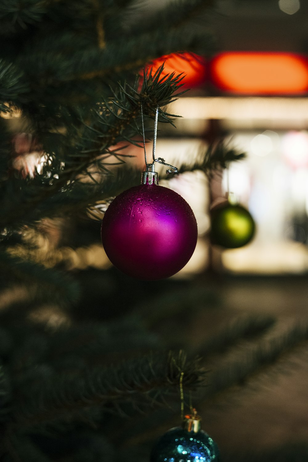 크리스마스 트리에 매달려 있는 보라색 값싼 물건의 클로즈업 선택적 초점 샷