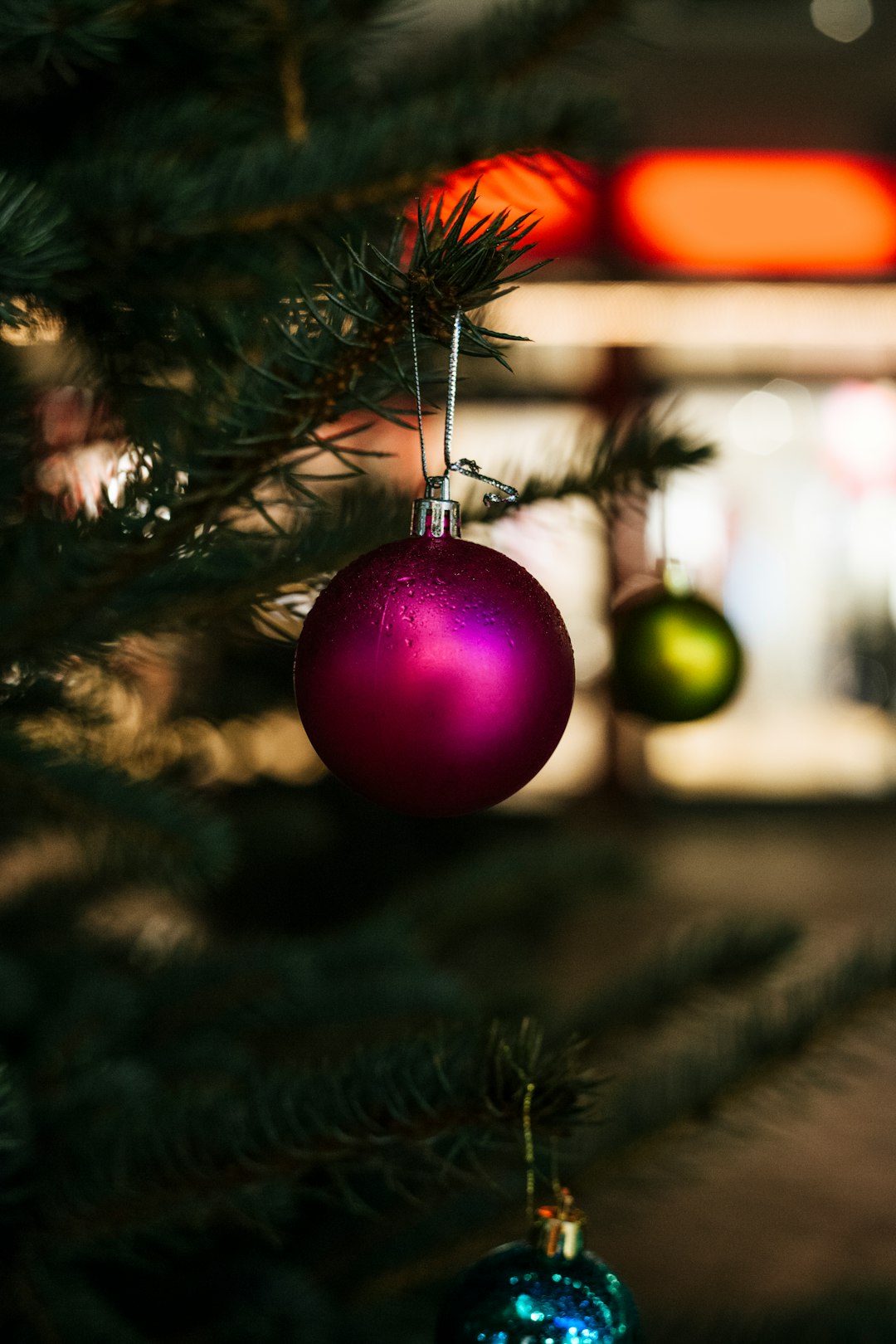 close-up selective focus shot of purple bauble hanging on Christmas tree