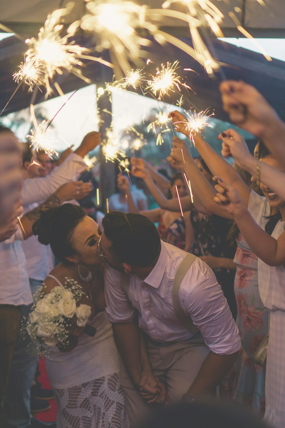 人々に囲まれて新婚のキス