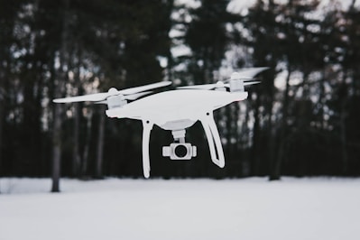 flying quadcopter drone near trees during winter