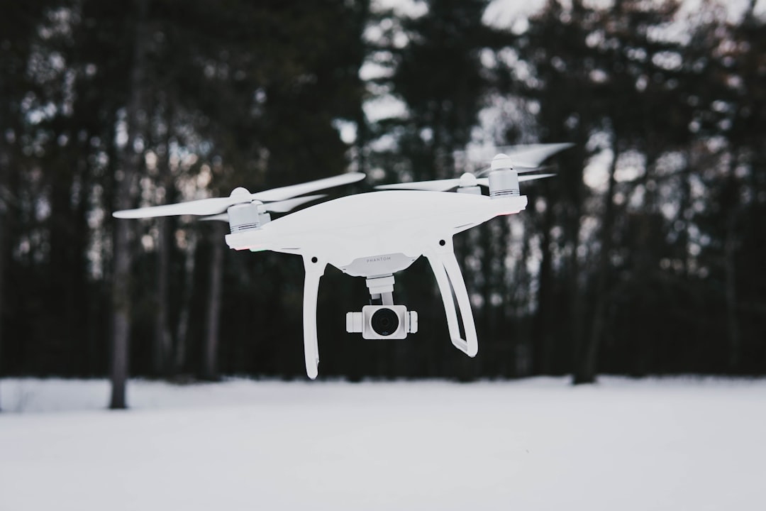 flying quadcopter drone near trees during winter