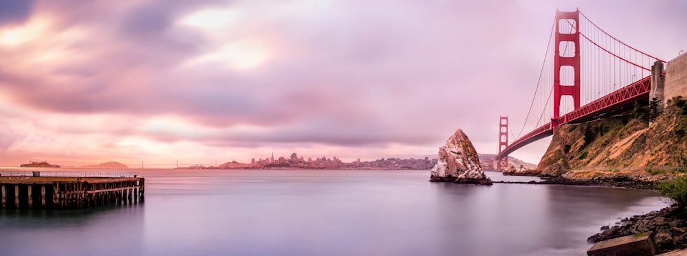 Vista panorámica del cuerpo de agua y el puente bajo el cielo nublado