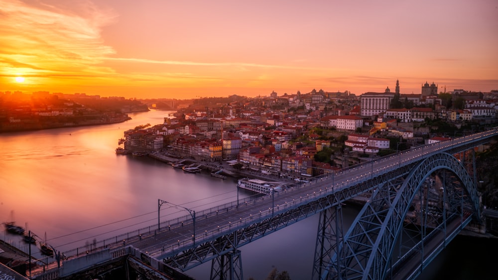 gray bridge near building at sunset