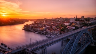 gray bridge near building at sunset