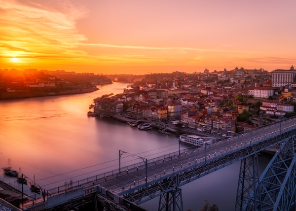 gray bridge near building at sunset