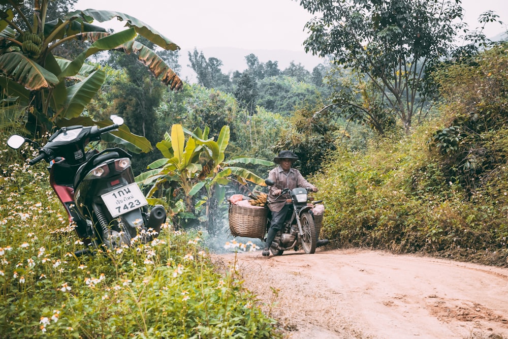 man riding motorcycle with wicker baskets during day