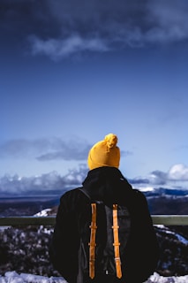man in black jacket under cloudy blue sky