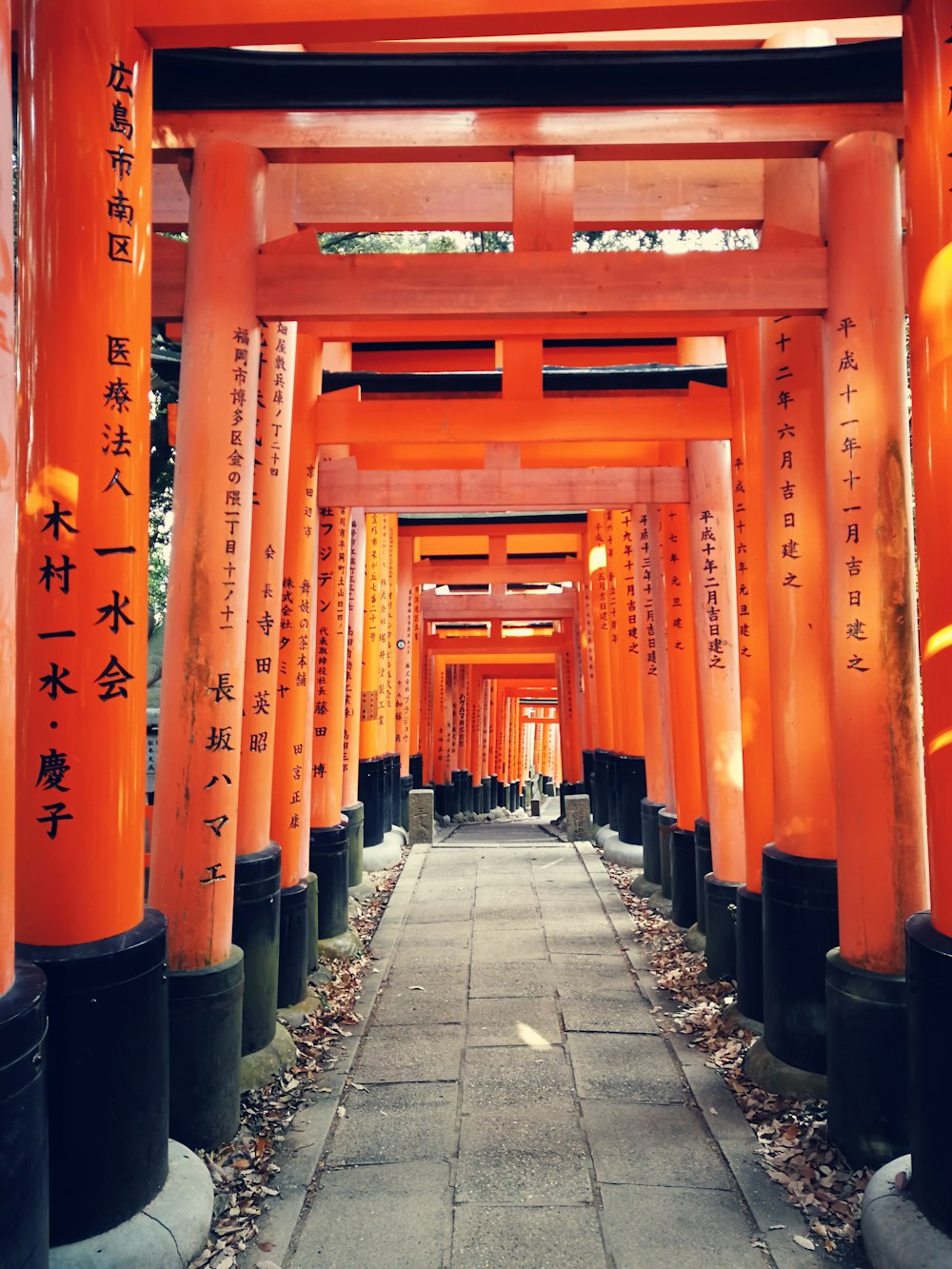 gray concrete pathway between red-and-black posts