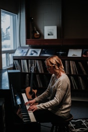 A joyful senior woman playing piano with a smile in a cozy living room.