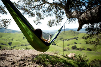 A peaceful scene of a person relaxing in a hammock under a clear blue sky, embodying pure relaxation.