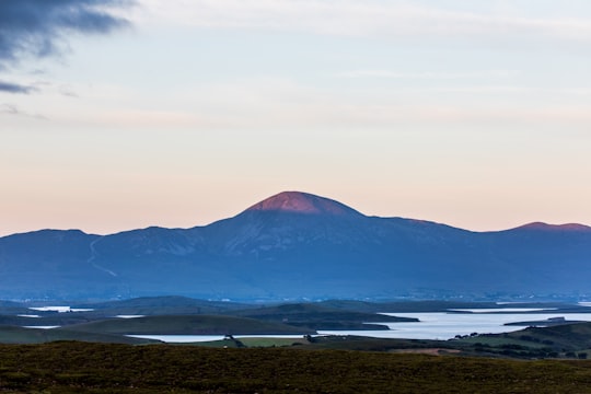 mountain near river during daytime in Connemara National Park Ireland