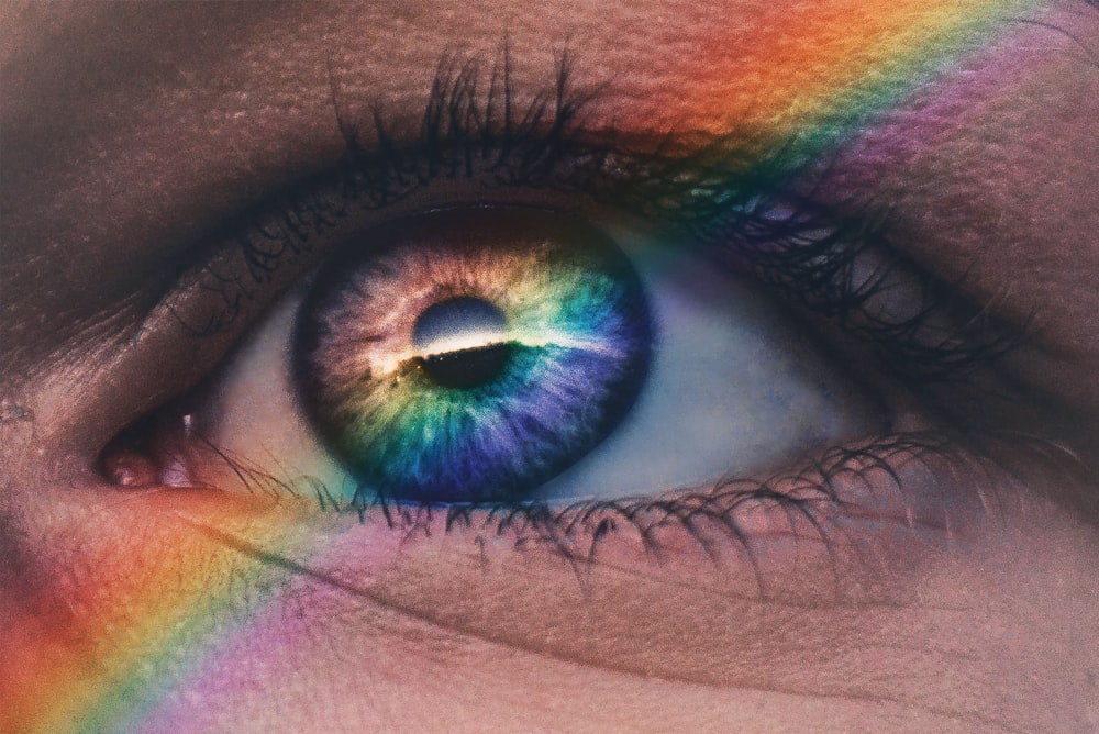 Photographie en gros plan des rayons arc-en-ciel sur l’œil