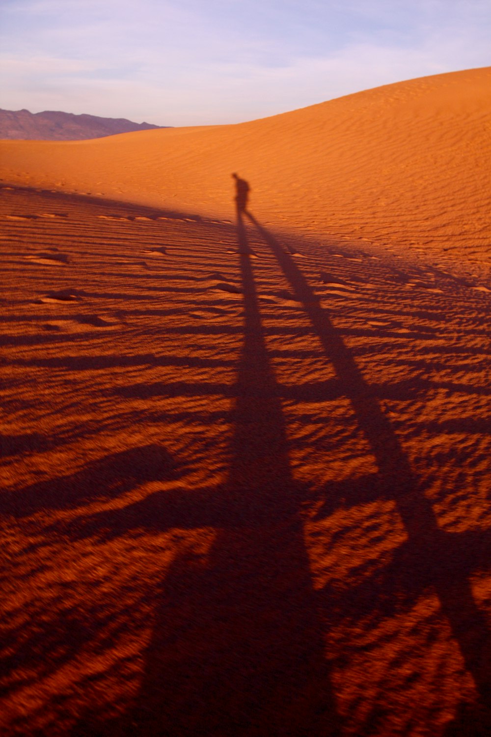 sombra de una persona que camina sobre el desierto