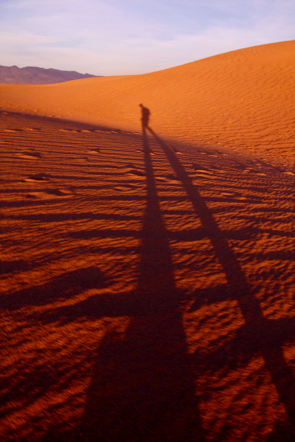 shadow of a person walking on desert