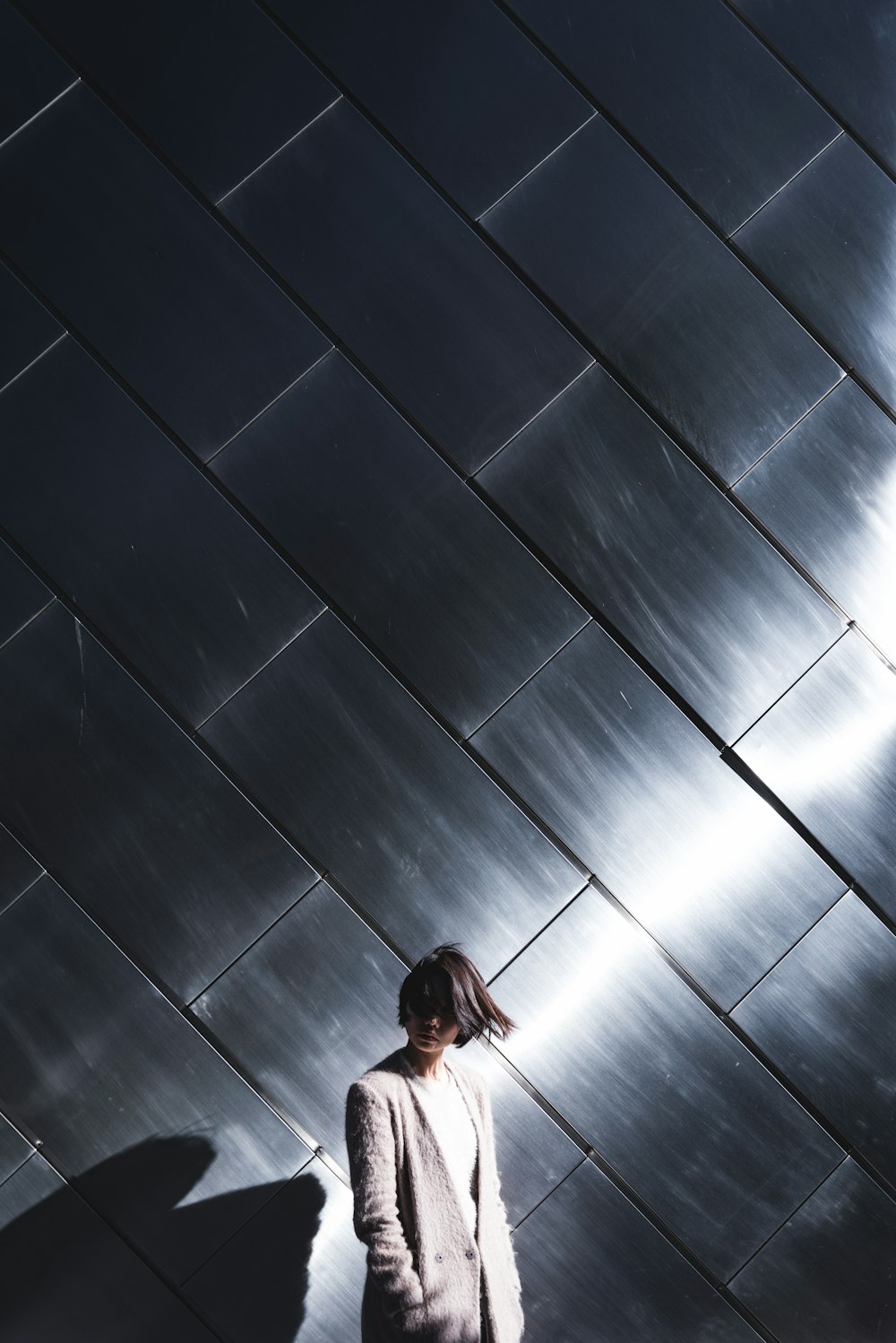 woman standing in-front silver wall