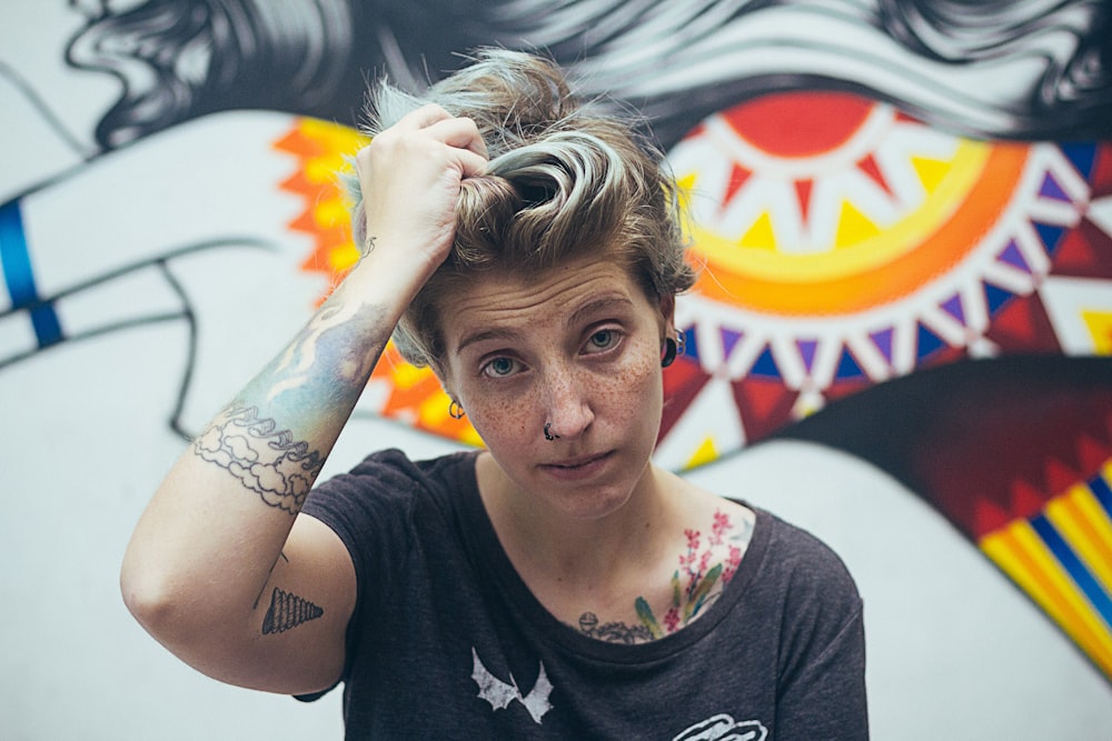 woman holding her hair near graphic wall