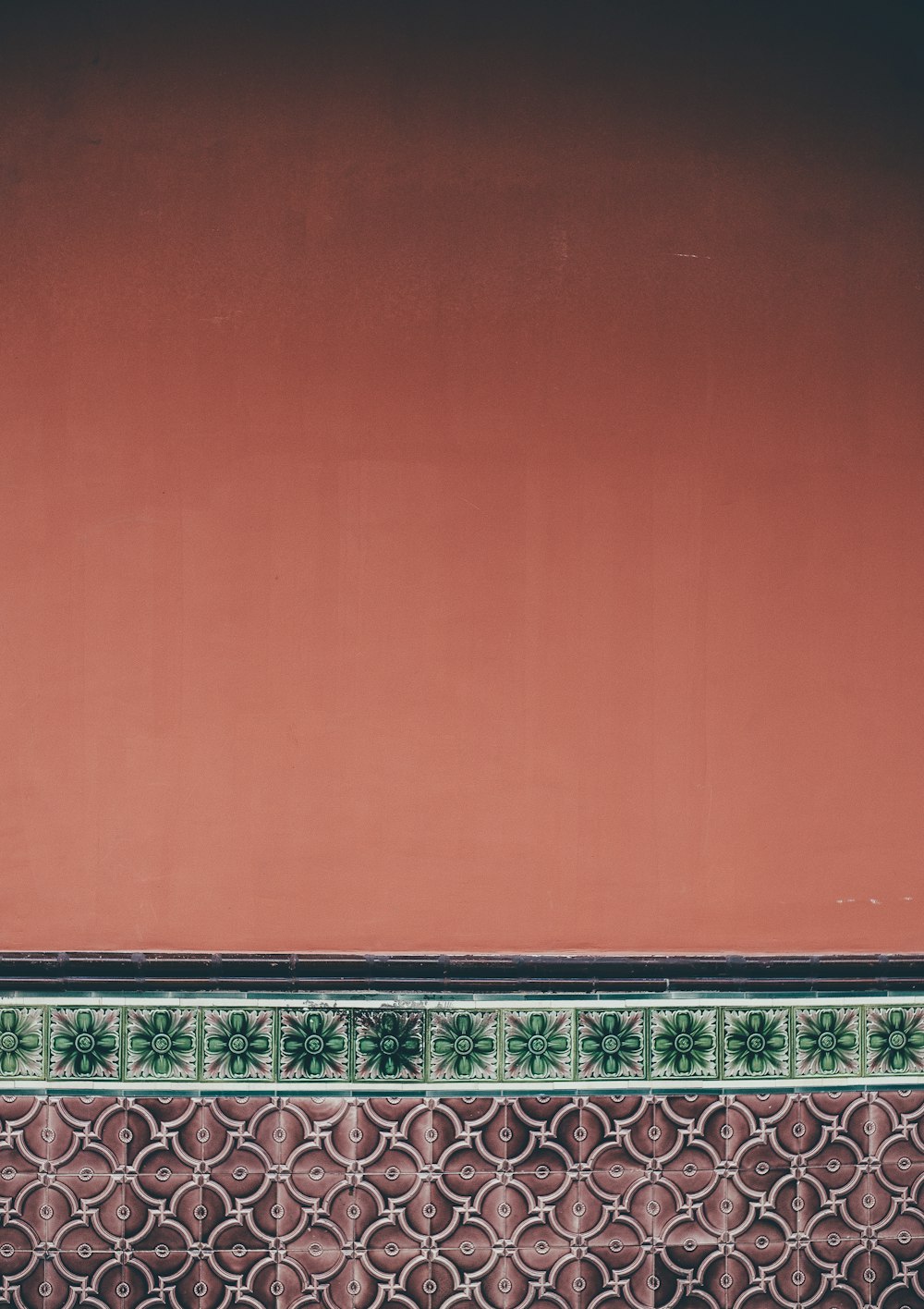 a person sitting on a bench in front of a red wall