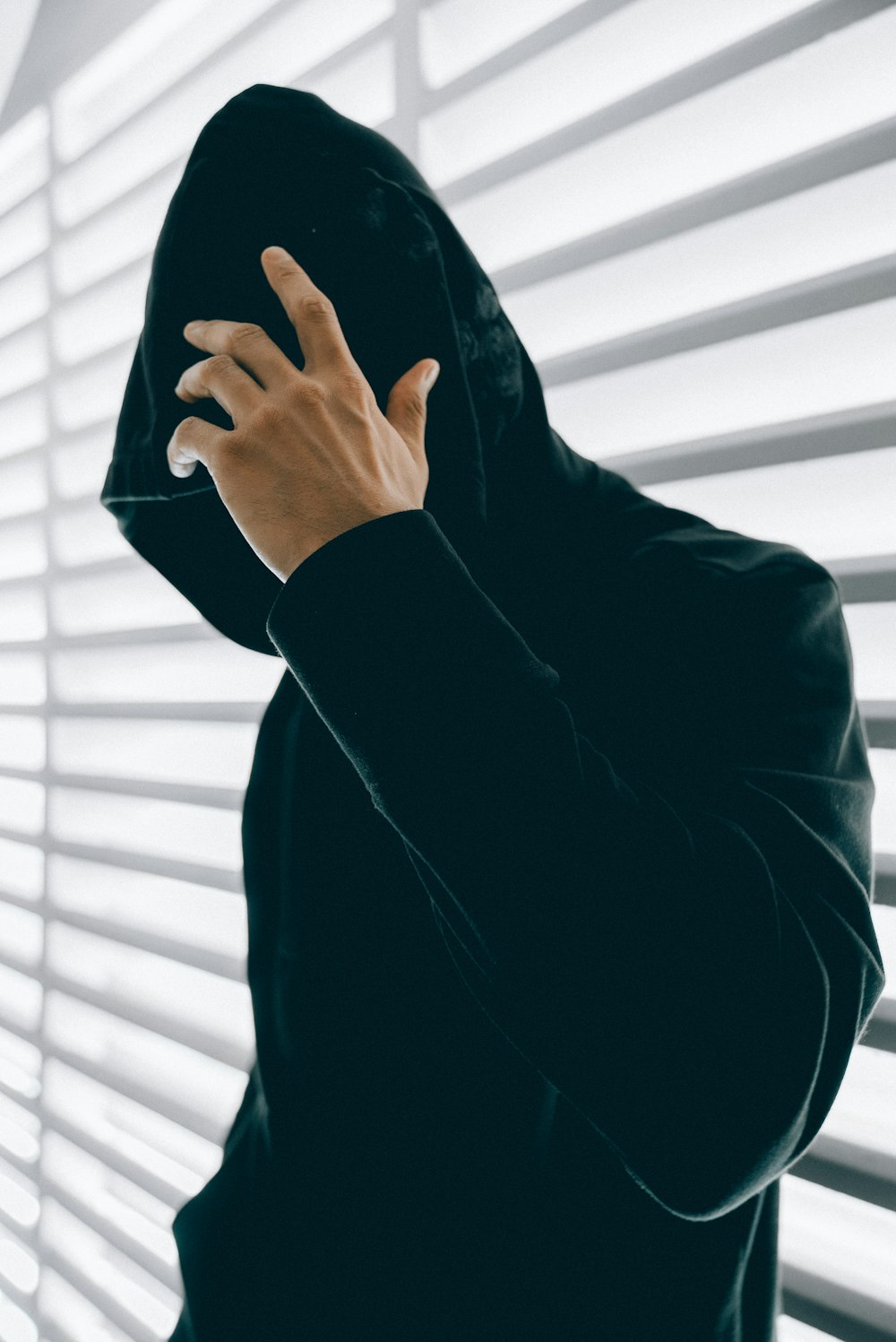 person wearing green hooded jacket inside room