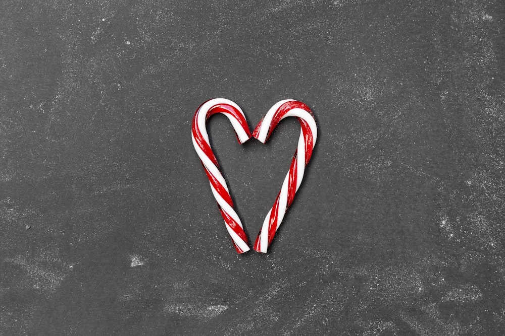 two red-and-white candy canes on gray surface