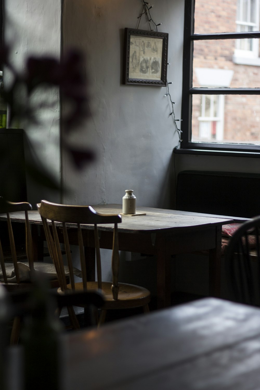 white plastic bottle on brown wooden table near glass window