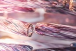 Close-up view of intricately detailed glass rods featuring a swirling pattern with a glossy finish. The rods exhibit a blend of colors that merge together to create an iridescent effect, emphasizing the delicate craftsmanship.