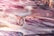 Close-up view of intricately detailed glass rods featuring a swirling pattern with a glossy finish. The rods exhibit a blend of colors that merge together to create an iridescent effect, emphasizing the delicate craftsmanship.