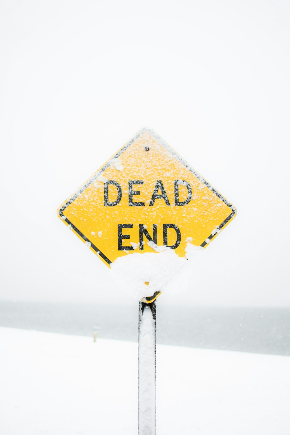 Fotografia de foco de sinal de estrada sem saída coberto de neve