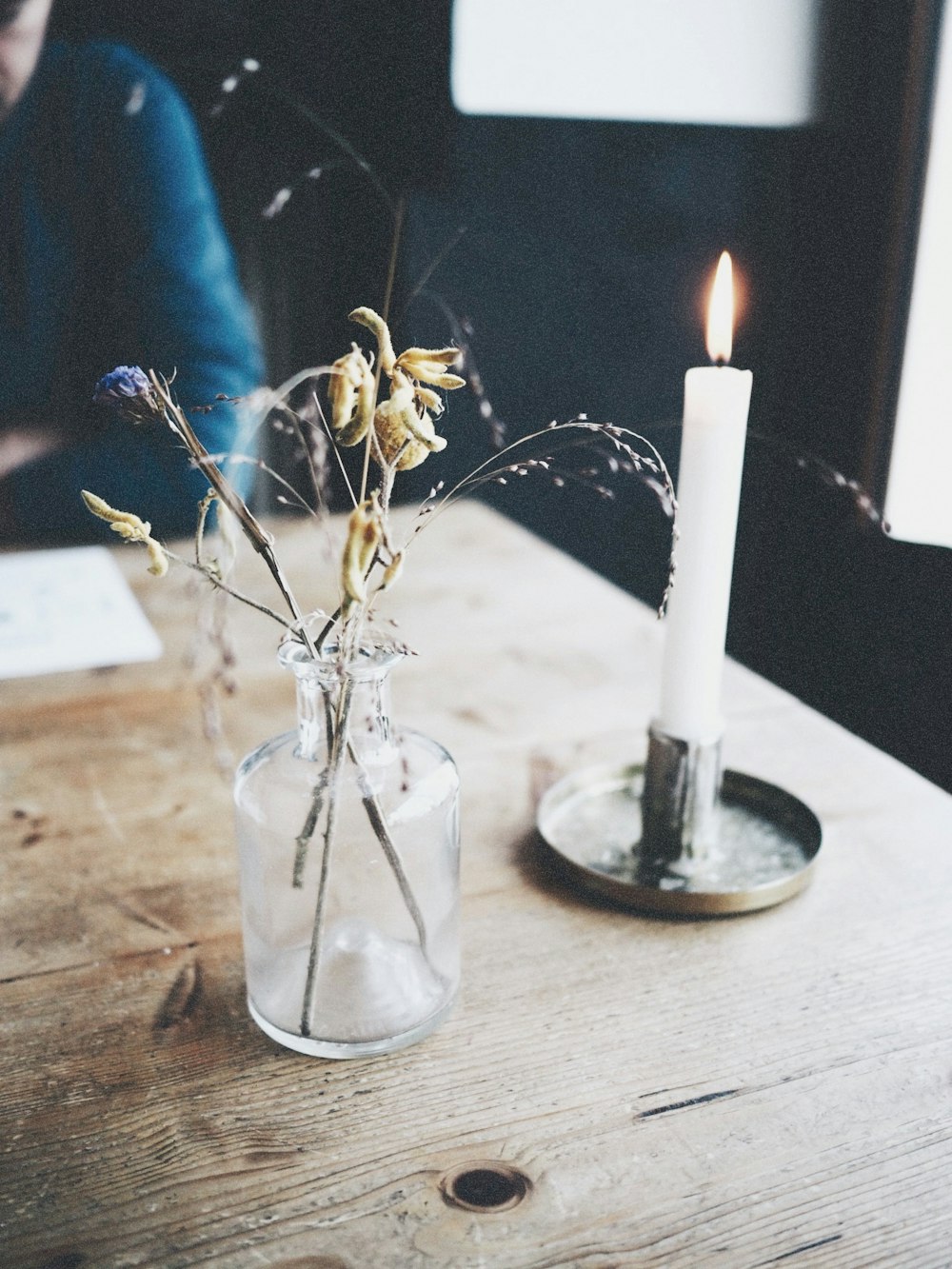 lighted white candle on brown wooden table