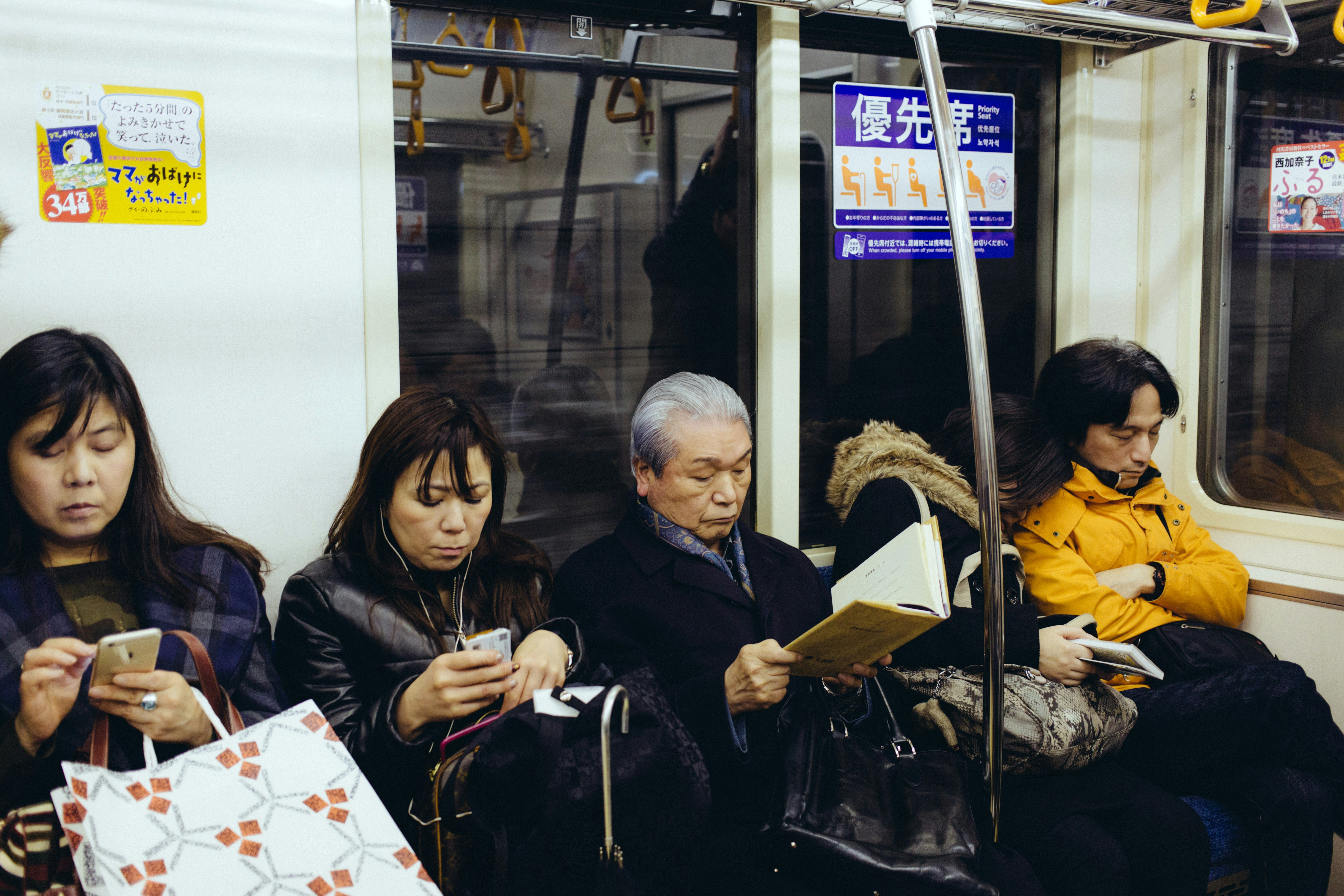 A diverse group of people, young and old, engrossed in their smartphones, showing various social media apps on screen.
