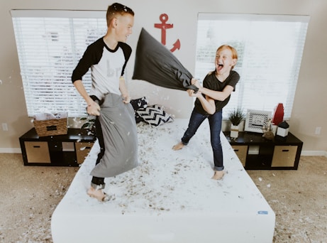 boy and girl having pillow fight